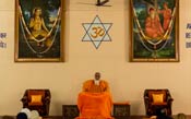 Swamiji sitting on the stage in the meditation hall