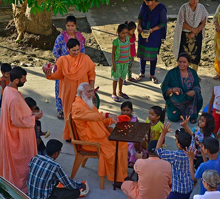 Swamiji throwing toffees