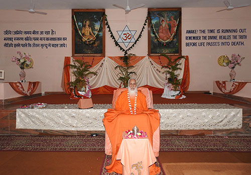 Gurudev with flower garland in the meditation hall