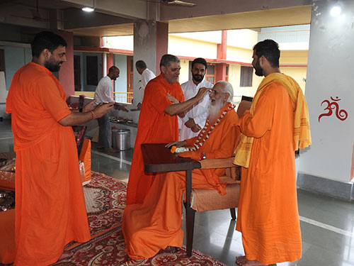 Sw.Premji putting tilak on Gurudev at the havan