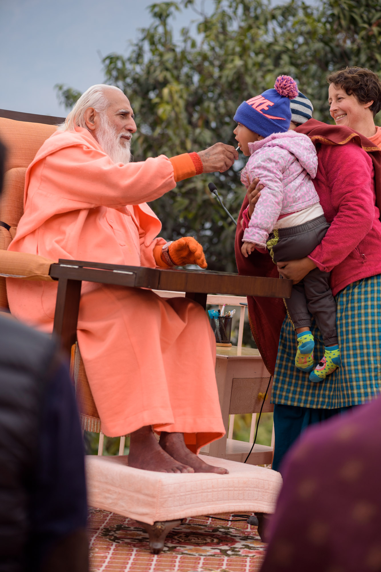 Swamiji feeding a lollipop to a child